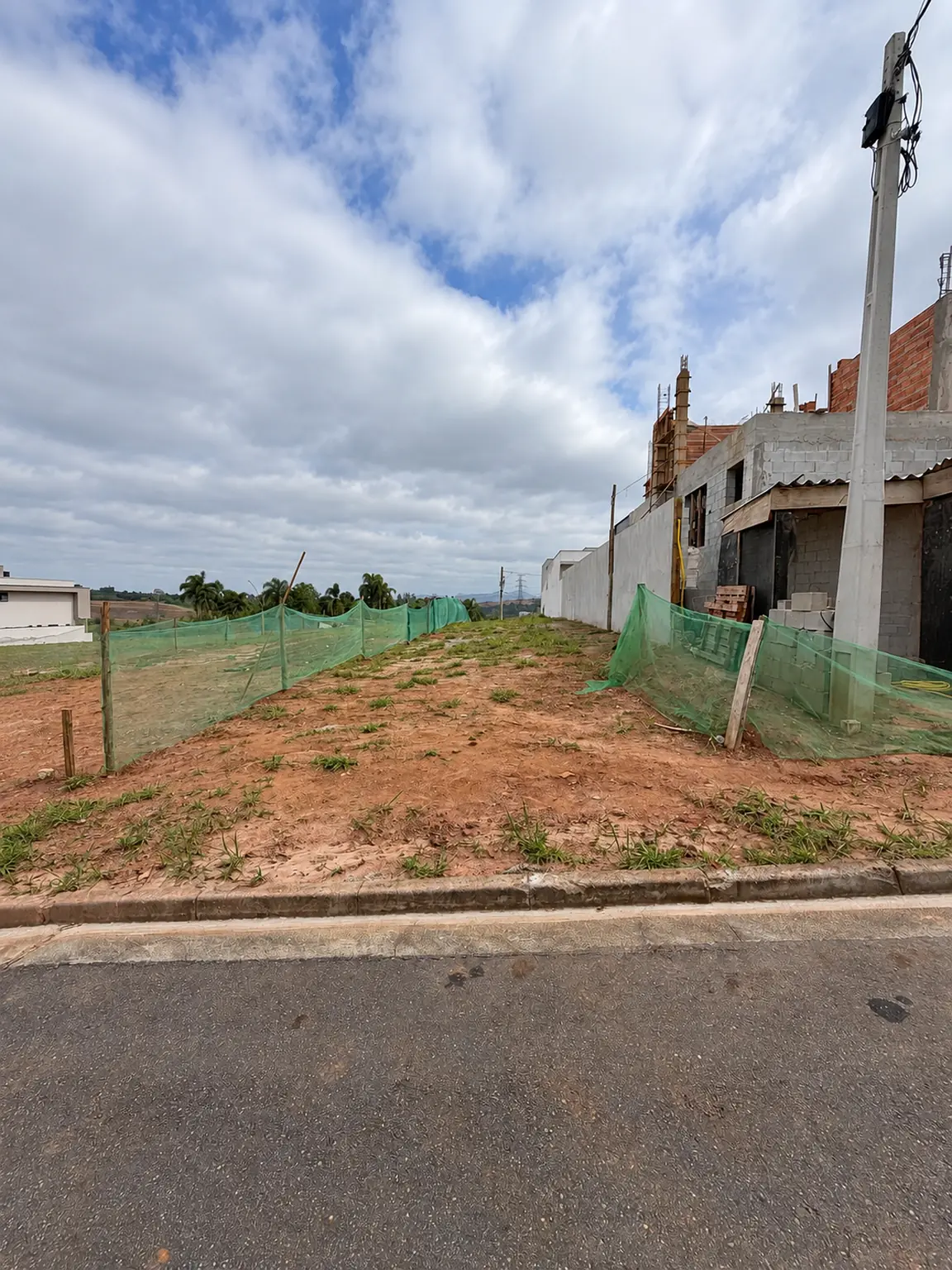 Lote no Paradise Gardens em Mogi das Cruzes, visto da rua junto à calçada