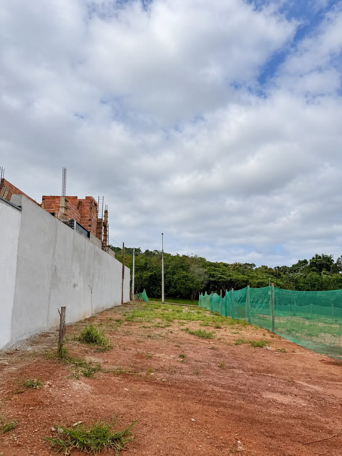 Outro ângulo do terreno junto ao muro lateral e à calçada