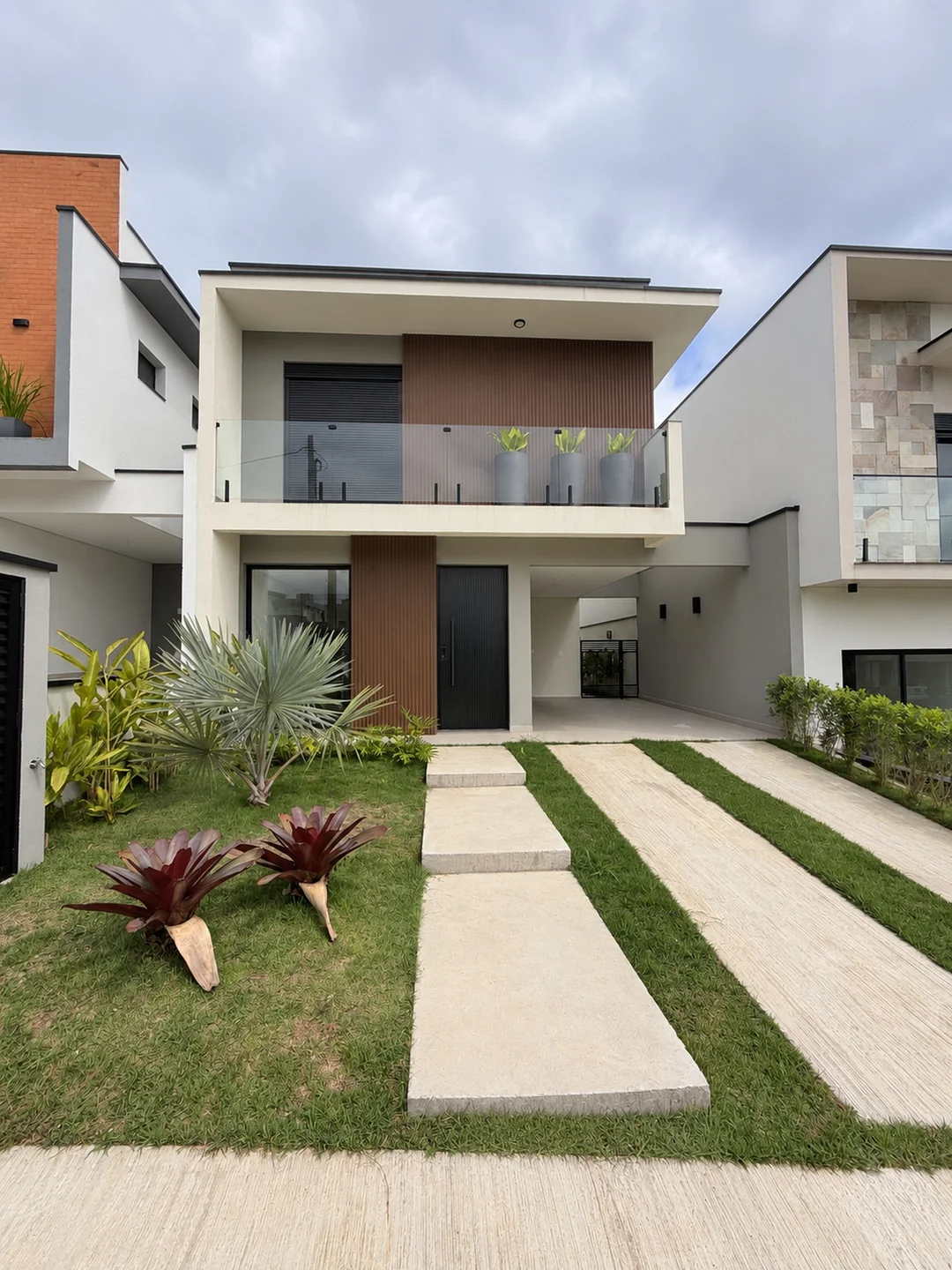 Fachada da casa no Paradise Gardens, em Mogi das Cruzes, com varanda e painel vertical