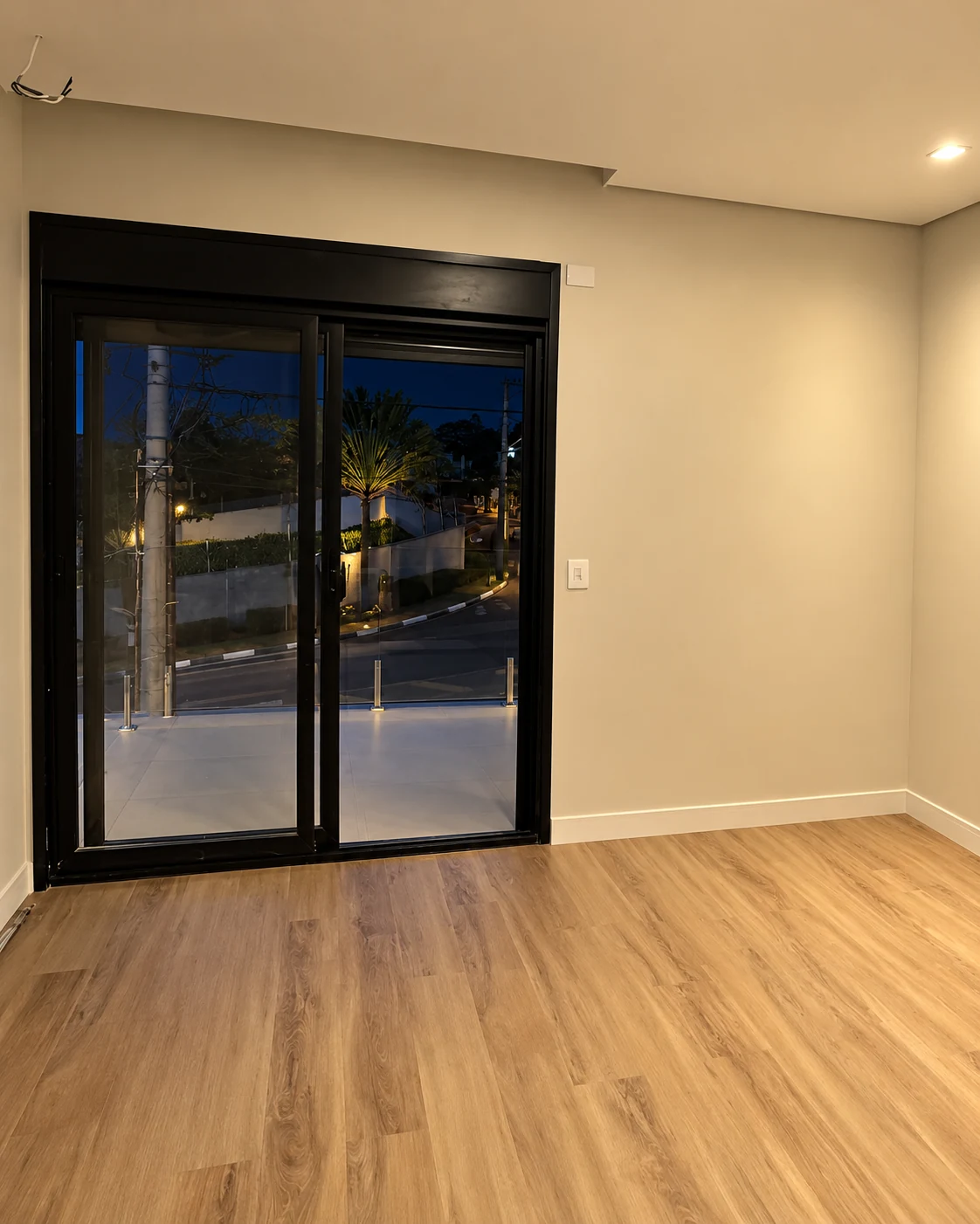 Dormitório com porta de vidro para a varanda — iluminação noturna editada
