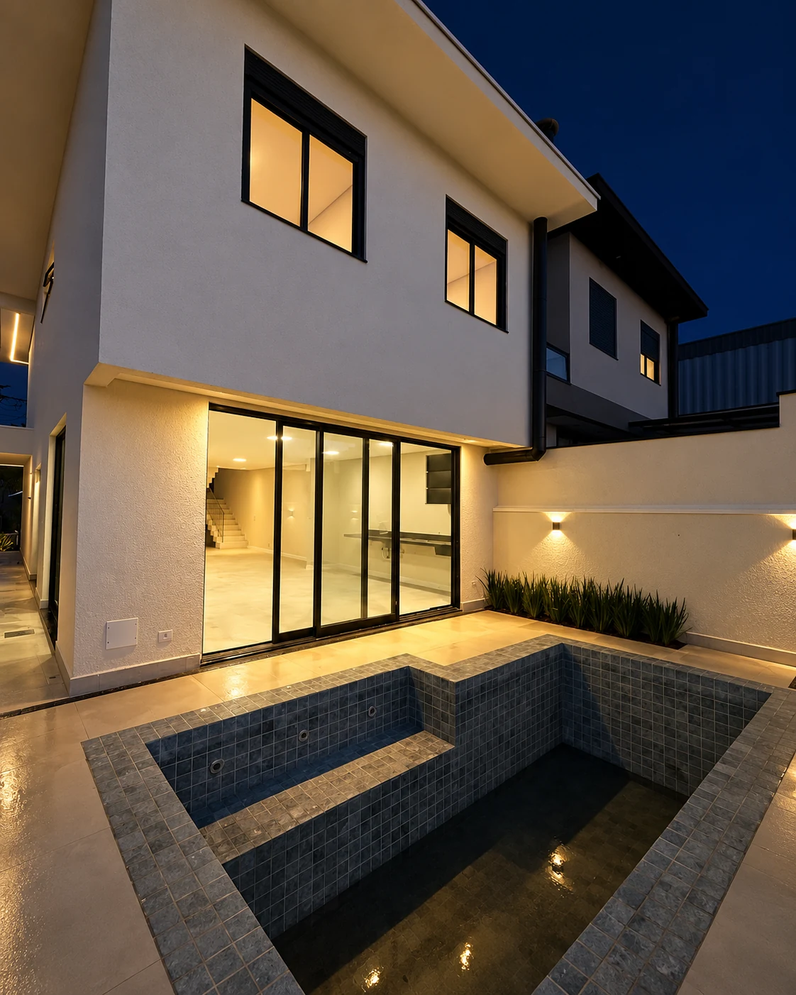 Piscina privativa e fachada dos fundos do sobrado — iluminação noturna editada